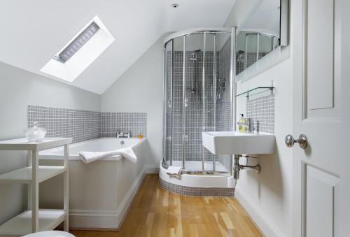 a white bathroom with a sink and a shower at Claytons Cottage in Adlestrop