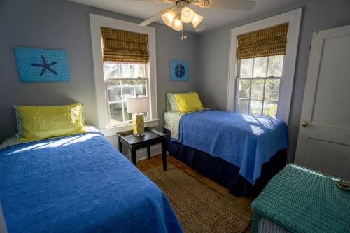 a bedroom with two beds and two windows at Graduations Welcome! Bayside Bungalow Close Proximity to Downtown Beaufort and Parris Island in Beaufort