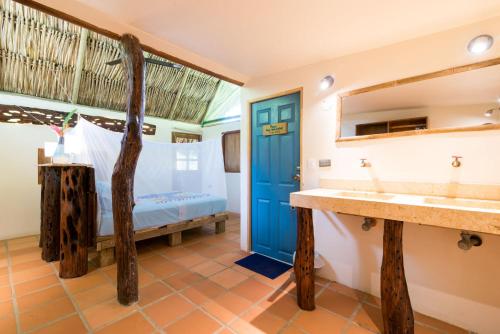 ein Bad mit einem Bett und einem Waschbecken in der Unterkunft Rio Hostel Buritaca in Buritaca