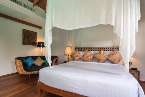 a bedroom with a large bed with a canopy at Tango Luxe Beach Villa, Koh Samui in Choeng Mon Beach