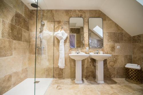 uma casa de banho com 2 lavatórios e um chuveiro em Hôtel du Domaine de La Groirie - Le Mans em Trangé