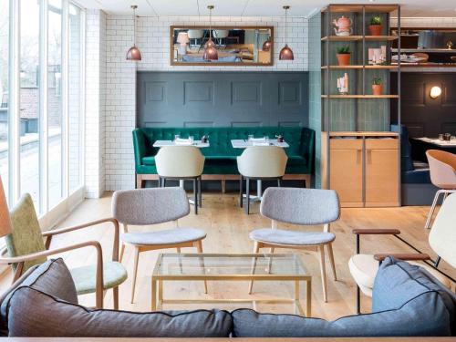 a restaurant with a couch and chairs and a table at Novotel York Centre in York