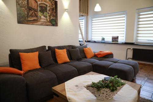 a living room with a blue couch and orange pillows at Landhaus Schlossberg in Medebach
