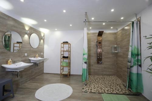 a bathroom with two sinks and a shower at Landhaus Schlossberg in Medebach