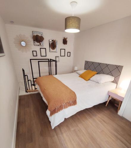 a bedroom with a large white bed with a brown blanket at Charmant duplex 2 pièces hypercentre de Granville in Granville