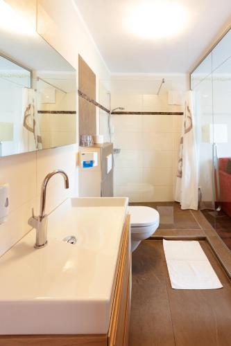 a bathroom with a sink and a toilet at Ferienhotel Herzog in Neumarkt am Wallersee