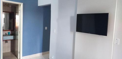 a flat screen tv on a wall in a room at Apartamento Mundi - Império Romano - Caldas Novas in Caldas Novas