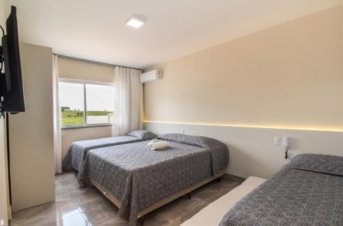Habitación de hotel con 2 camas y ventana en Pousada Espindola, en Penha