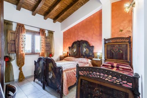 een slaapkamer met een antiek bed in een kamer bij Agriturismo Monte Criscione in Avola