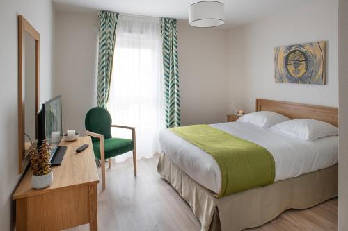 um quarto com uma cama, uma secretária e uma televisão em Résidence DOMITYS - L'Athénée em Mont-Saint-Aignan