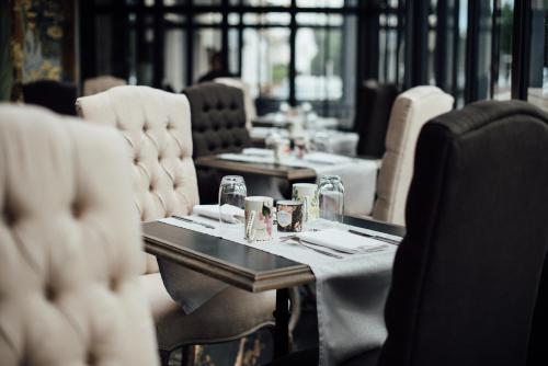 - une salle à manger avec des tables, des chaises, des verres et des assiettes dans l'établissement Amirauté, à La Baule