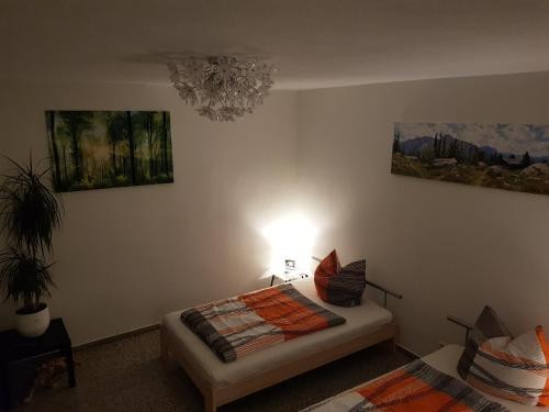 ein Schlafzimmer mit einem Bett mit einer Lampe und Gemälden in der Unterkunft Ferienwohnung-Balaro Apt I EG-Wohnung mit großer Terrasse! in Weil im Schönbuch