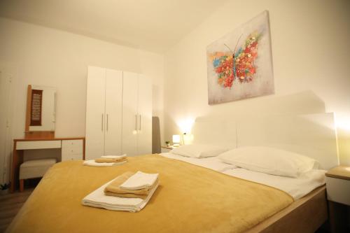 a bedroom with a large bed with towels on it at InOsijek- FEELS LIKE HOME in Osijek