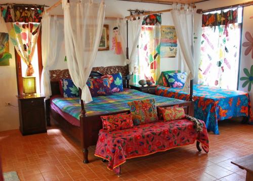 Varinda Resort في شاطئ لاماي: غرفة نوم بسريرين واريكة وكرسي