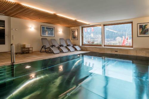 a large swimming pool with chairs in a room at Apartments Tschanun in Gaschurn