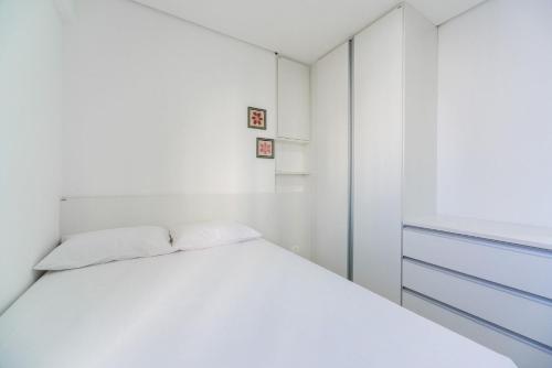 ein weißes Schlafzimmer mit einem Bett und einem Fenster in der Unterkunft Sossego com excelente localização em Boa Viagem in Recife