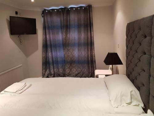 1 dormitorio con cama blanca y ventana en Blagrave Rooms, en Reading