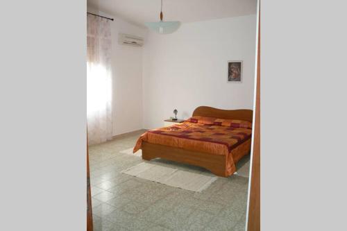 een slaapkamer met een bed en een spiegel bij Mariangela's Home in Carbonia