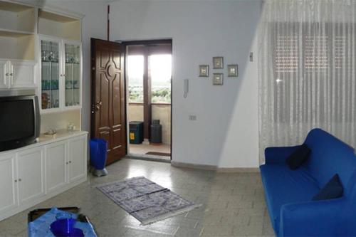een woonkamer met een blauwe stoel en een televisie bij Mariangela's Home in Carbonia
