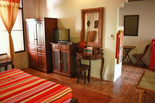 um quarto com uma cama e uma mesa com uma televisão em Varinda Resort em Lamai