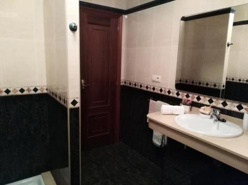 ein Bad mit einem Waschbecken und einem Spiegel in der Unterkunft Insua in Malpica