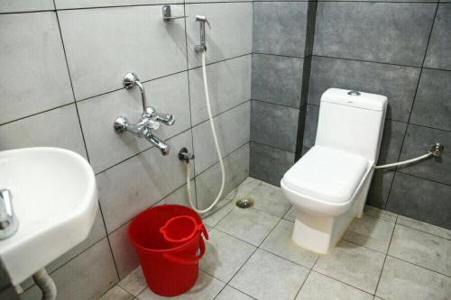 a bathroom with a white toilet and a sink at Hotel Delma in Chennai