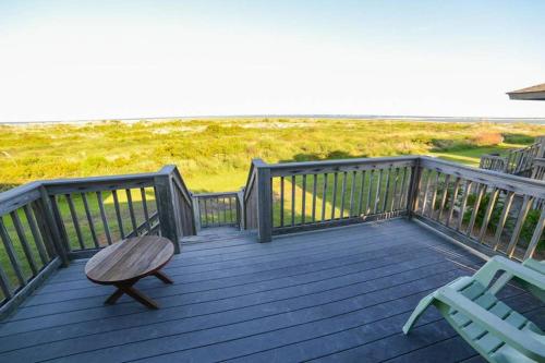 a wooden deck with two chairs and a bench at Pelican Point Unobstructed Beach Views Beach Access out back door! in Harbor Island