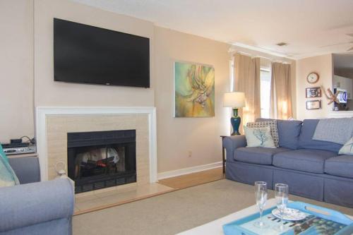a living room with a blue couch and a fireplace at Pelican Point Unobstructed Beach Views Beach Access out back door! in Harbor Island