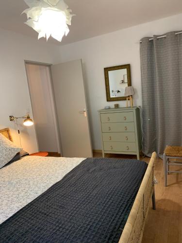 - une chambre avec un lit, une commode et une lampe dans l'établissement T2 cosy 70s, à Avignon