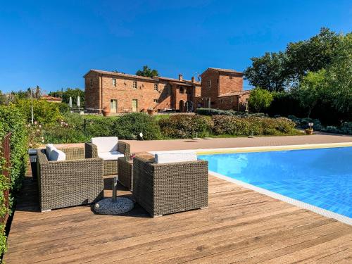 un patio con sillas de mimbre junto a una piscina en Casale Cardini, en Foiano della Chiana