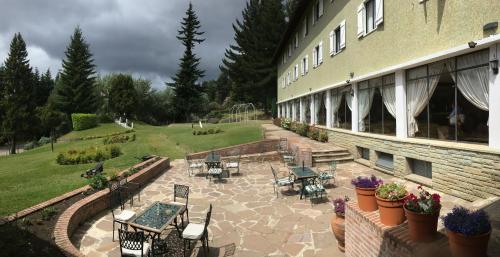 eine Terrasse eines Gebäudes mit Tischen und Stühlen in der Unterkunft Gran Hotel Panamericano in San Carlos de Bariloche