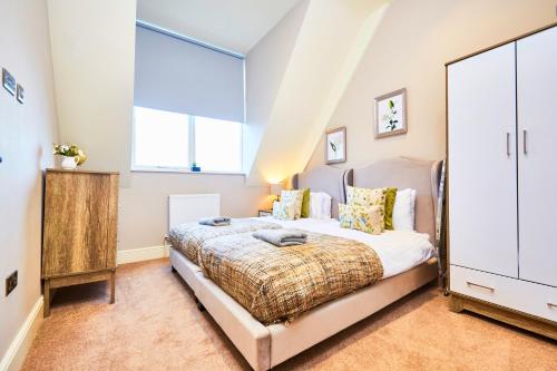 um quarto com uma cama e uma grande janela em Stunning Gems of Harrogate em Harrogate