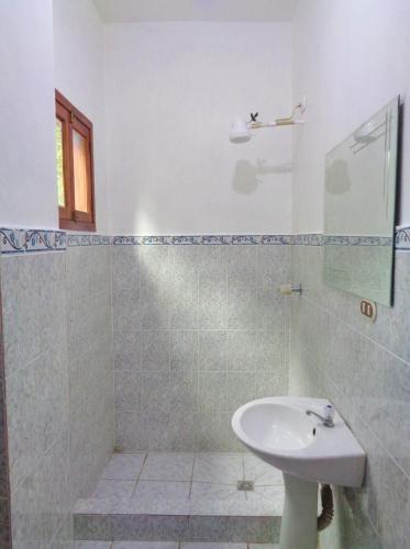 a white bathroom with a sink and a shower at Livingston Resort Hotel in Lívingston