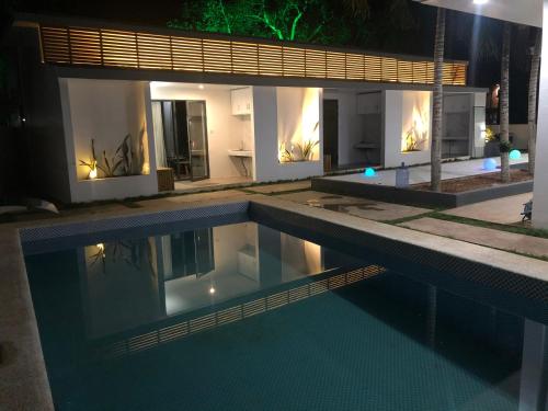 a swimming pool in front of a house at night at Bohol Sojourn Villa Alona in Panglao