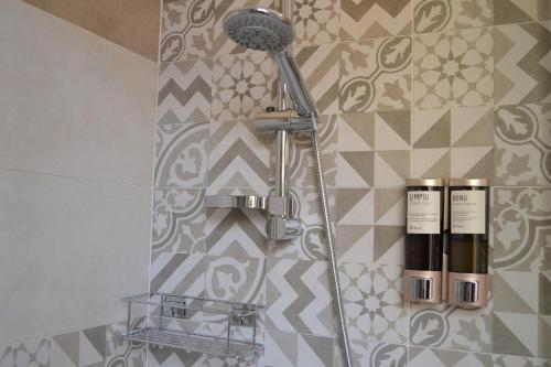 a shower in a bathroom with a microphone on a wall at Nuscos Bed and Breakfast in Nuoro