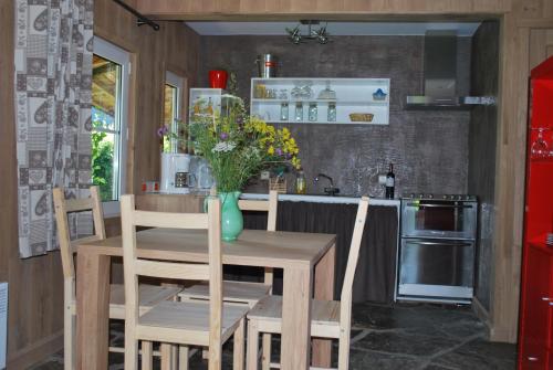 a kitchen with a table and chairs and a kitchen with a refrigerator at Le Chalet à Bonnerue in Houffalize