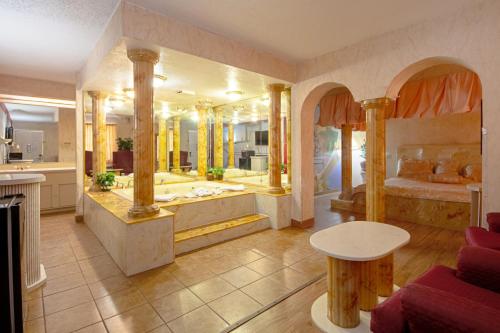 a large bathroom with a tub and a bedroom at Economy Inn & Suites in Denton