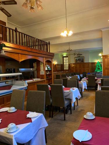 a dining room with tables and chairs and a staircase at The Star Hotel in Southampton