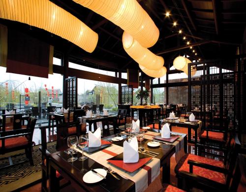 a restaurant with tables and chairs and a large window at Banyan Tree Lijiang in Lijiang
