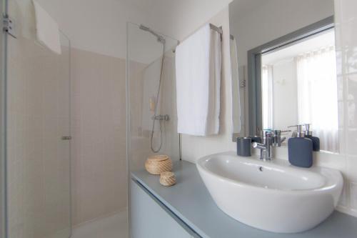 a white bathroom with a sink and a shower at Citybreak-apartments Coliseu in Porto