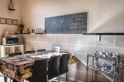a dining room with a table with chairs and a chalkboard at Stop & Sleep Bergamo in Bergamo