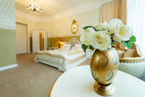 ein Schlafzimmer mit einer Vase mit weißen Blumen darin in der Unterkunft Hotel Pension Dahlem in Berlin