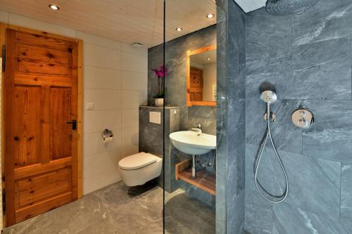 グリンデルワルトにあるFerienwohnung Alpenglühenのバスルーム(シャワー、洗面台、トイレ付)