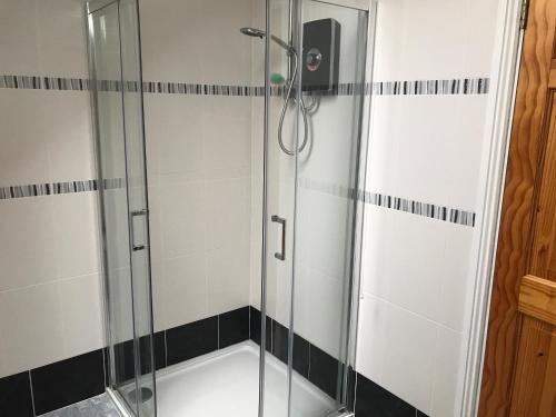 a shower with a glass door in a bathroom at Rose of the Sea in Belmullet