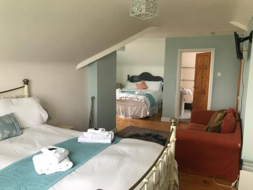 a bedroom with a bed and a couch and a chair at Rose of the Sea in Belmullet