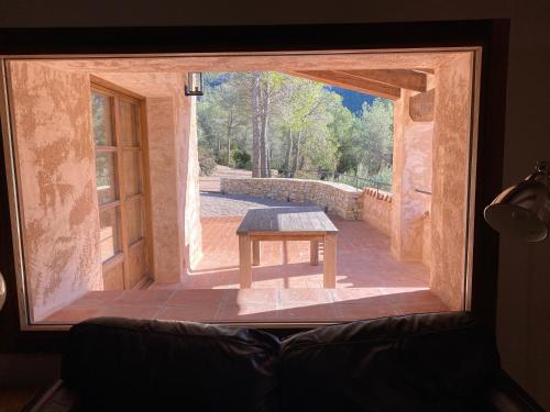 a view of a room with a table through a window at CAL PUIG, ENOTURISMO RURAL entre Viñas y Bosques in Juncosa