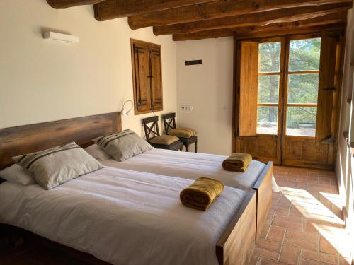 a bedroom with a large bed with two pillows on it at CAL PUIG, ENOTURISMO RURAL entre Viñas y Bosques in Juncosa
