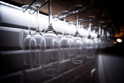 a row of wine glasses hanging from a rack at Apartmány Habánská, celý dům in Pouzdřany