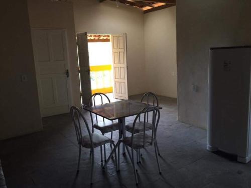 stół i krzesła w pokoju z oknem w obiekcie Residencial Santos w mieście Nova Viçosa