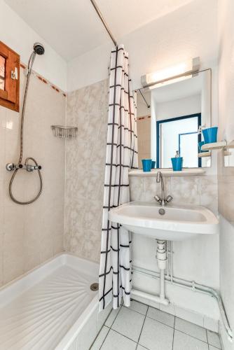 une salle de bain avec un lavabo et une douche dans l'établissement Arcadia Appartement - Vue sur Mer, à Gruissan
